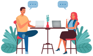 Two people talking to each other at a table with laptops